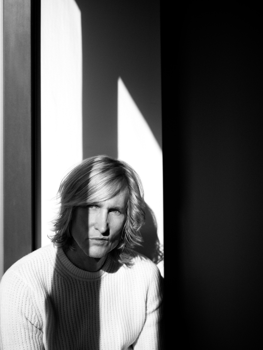 Scott Woodward in a white ribbed sweater, half his face in window light